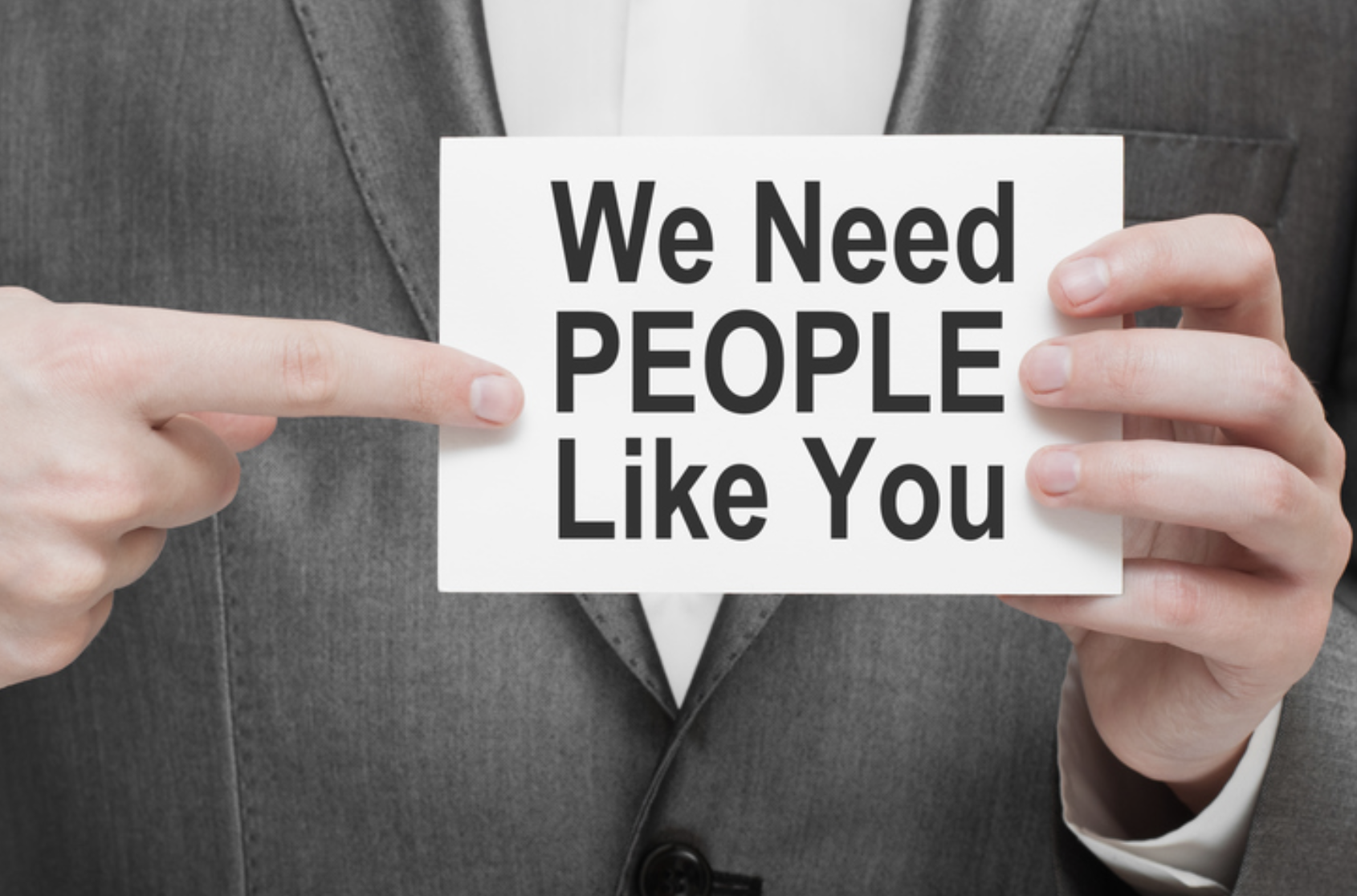 Man holding a sign, we need people like you